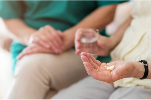 An elegant senior woman pours tea at home, creating a cozy and relaxed atmosphere.